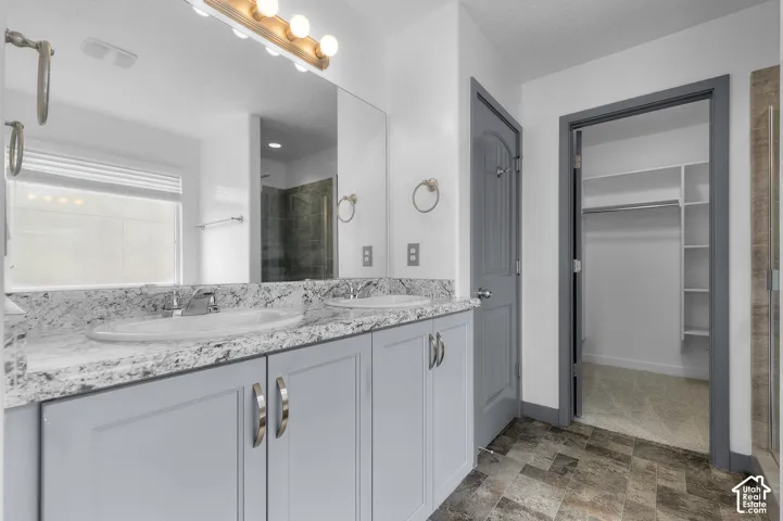 Dual vanity with light-toned cabinetry and stone countertops