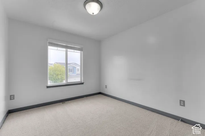 Carpeted flooring, white walls, and a window with blinds