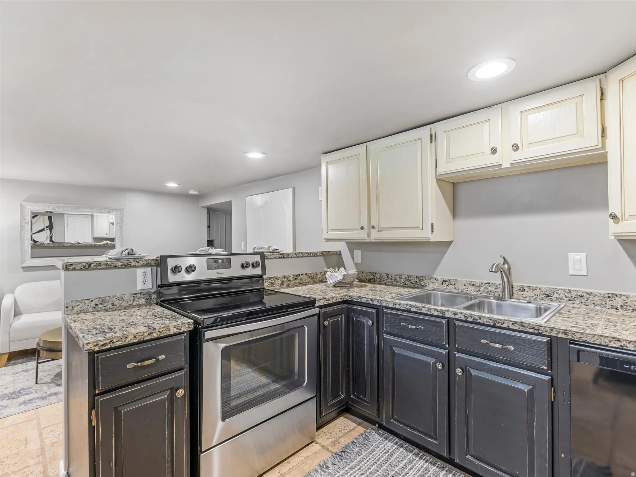 Kitchen featuring a stainless steel electric range, double basin sink, granite-style countertops, and recessed lighting