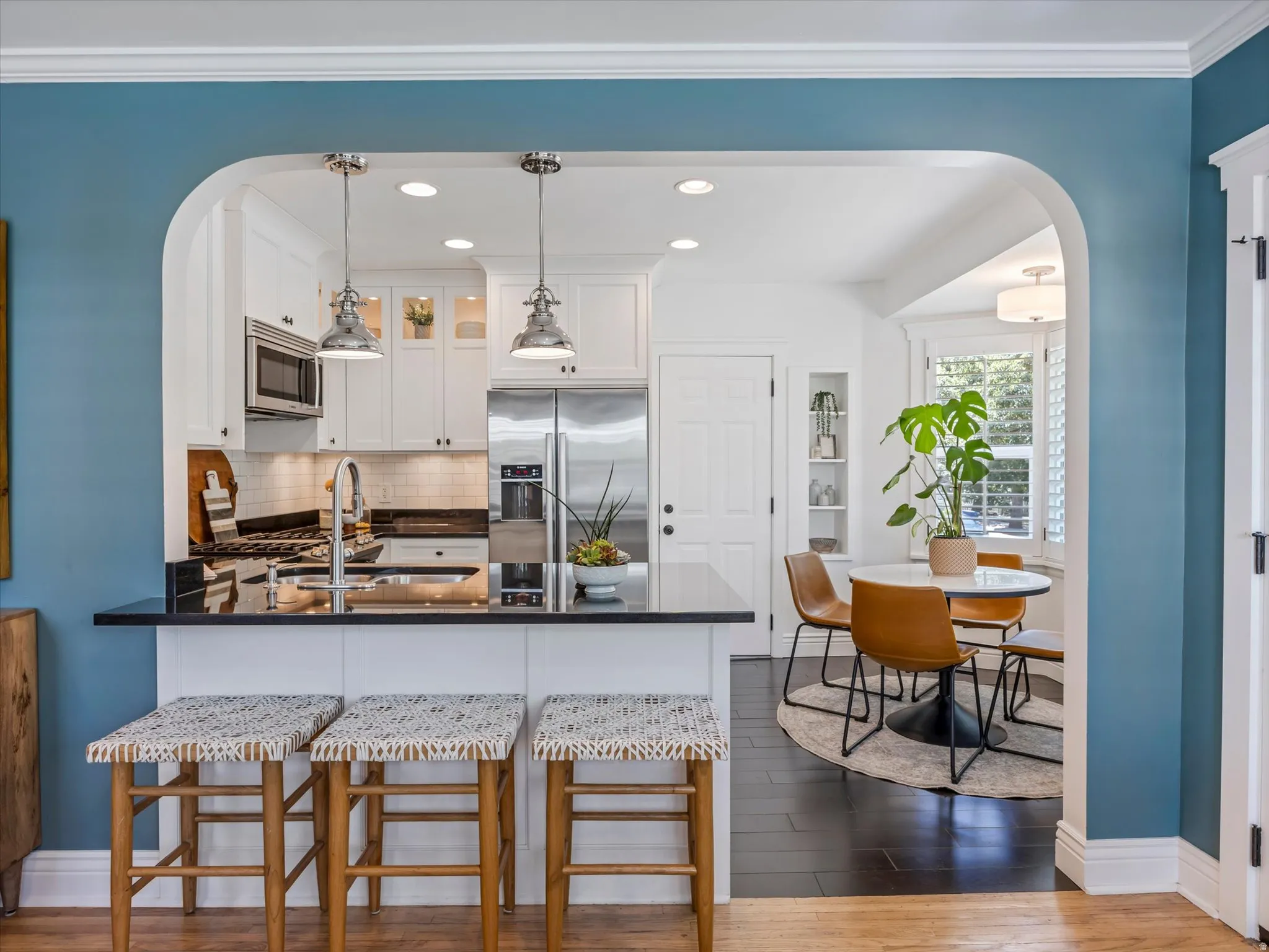 Kitchen featuring stainless steel appliances, white cabinetry, dark countertops, a built-in microwave, and recessed lighting