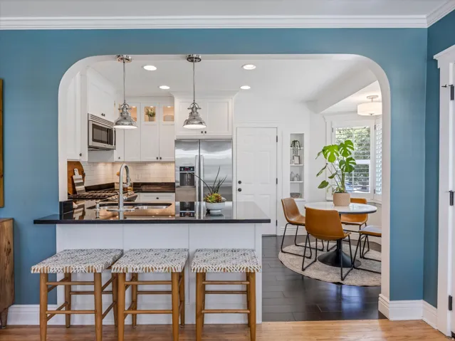 Kitchen featuring stainless steel appliances, white cabinetry, dark countertops, a built-in microwave, and recessed lighting