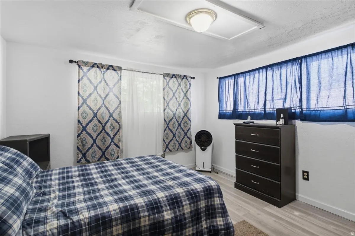 White walls with two distinct window treatments, including patterned drapes and blue sheer curtains