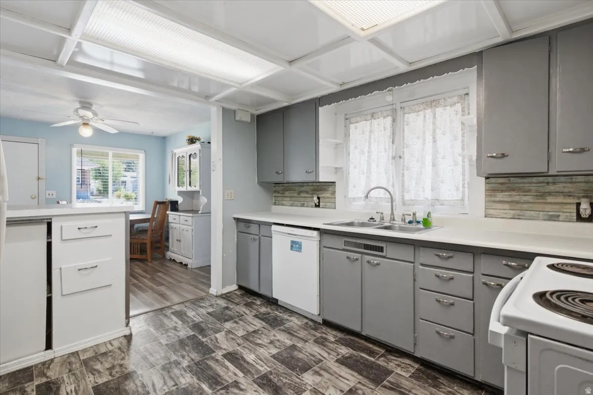Kitchen featuring grey cabinetry, light countertops, and a tile backsplash