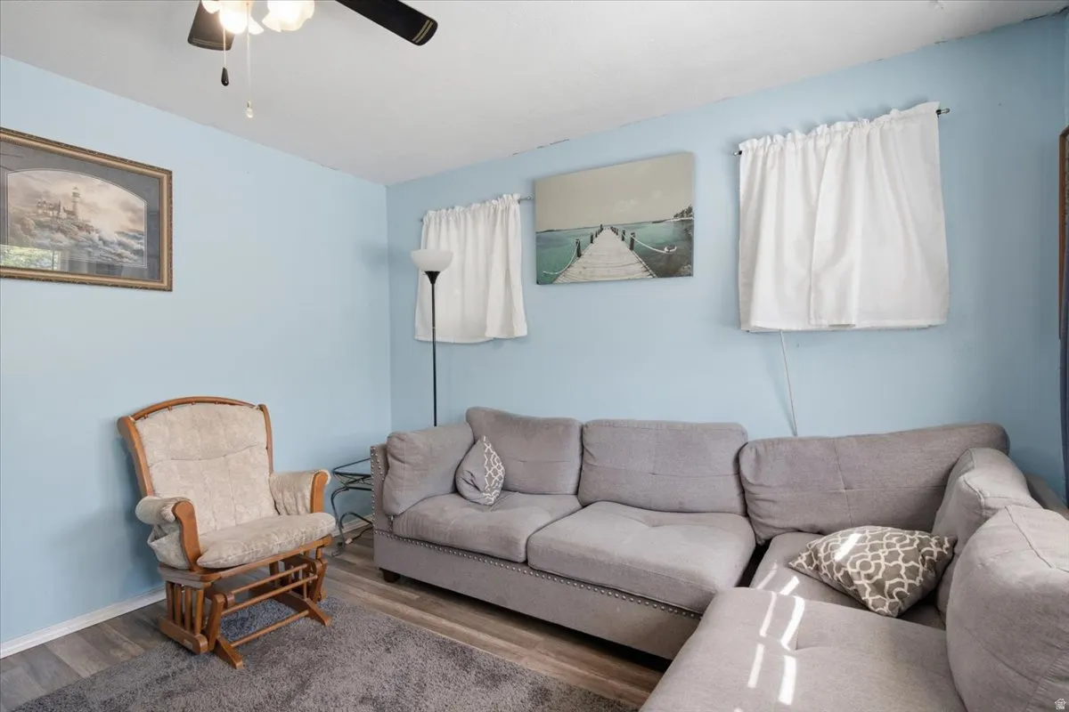 Living area featuring light blue walls and wood-finish flooring