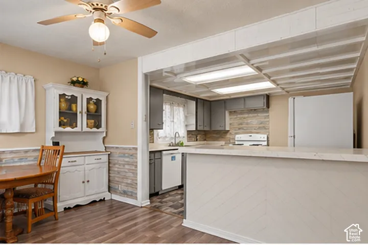 Kitchen featuring gray cabinetry, a white stove, and a white dishwasher