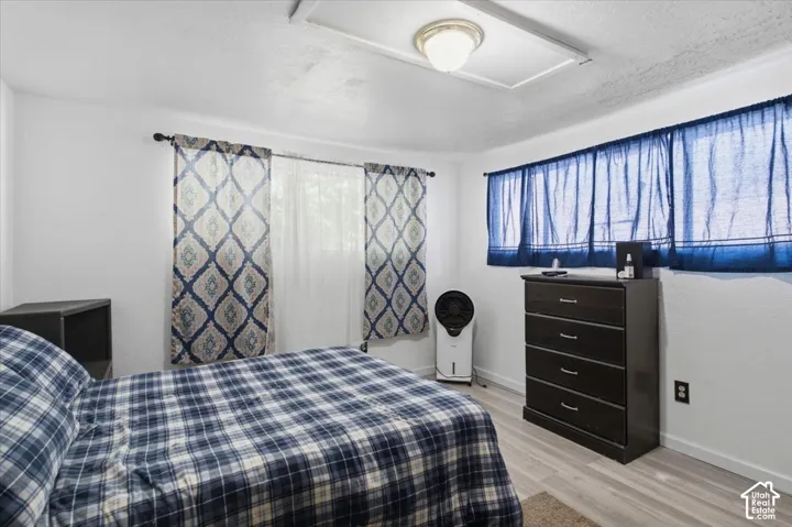 White walls with two distinct window treatments, including patterned drapes and blue sheer curtains