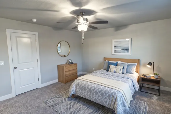 Gray wall paint, white trim, paneled door, ceiling fan with light, and carpeted flooring