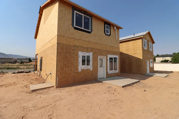 Modern two-story residence featuring brick and composite exterior cladding, multi-pane windows, and a covered entry porch