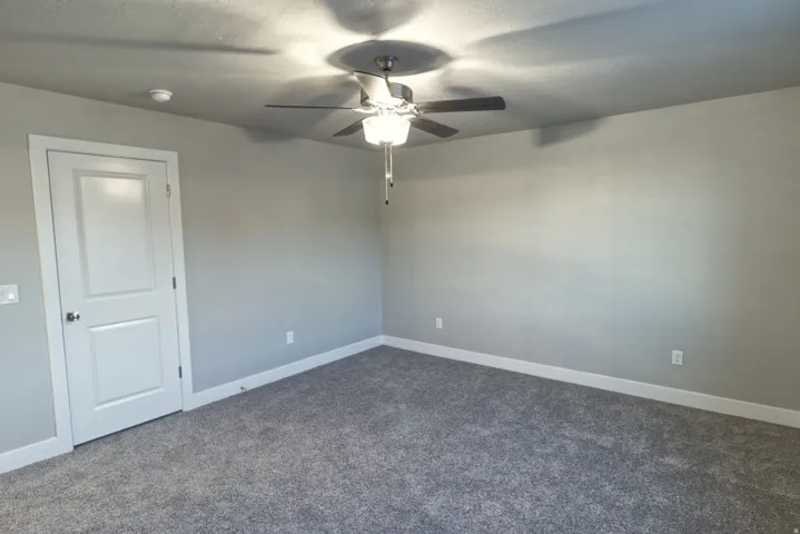 Previous build home - colors and selections may vary. Carpeted flooring, ceiling fan with integrated lighting, neutral wall palette, white trim, and white paneled door