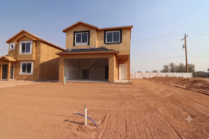 New construction featuring an attached garage, multiple windows, and a white entry door
