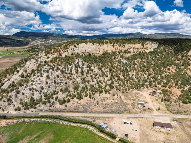 Expansive mountainous terrain with varied elevations, featuring scattered evergreen trees