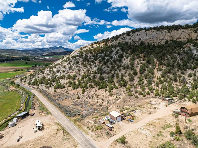 Expansive natural landscape with a prominent rock face and abundant evergreen trees