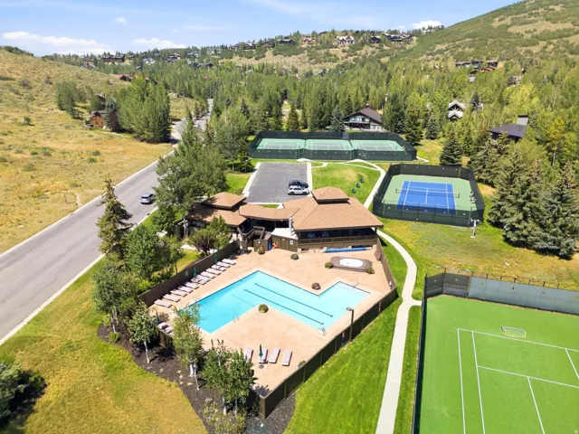 Outdoor swimming pool with integrated spa, multiple tennis courts, and sport court