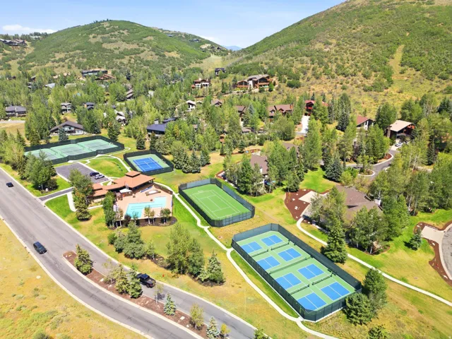Resort-style amenities featuring multiple tennis courts, pickleball courts, and a swimming pool with a surrounding patio