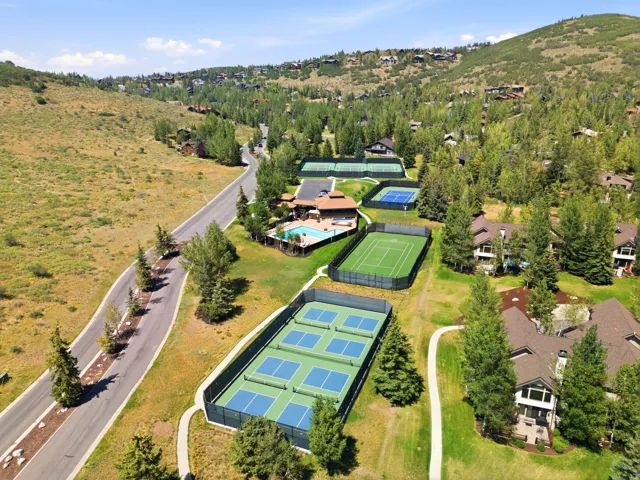 Multiple outdoor tennis courts, multiple pickleball courts, outdoor swimming pool, extensive green spaces, and mature landscaping