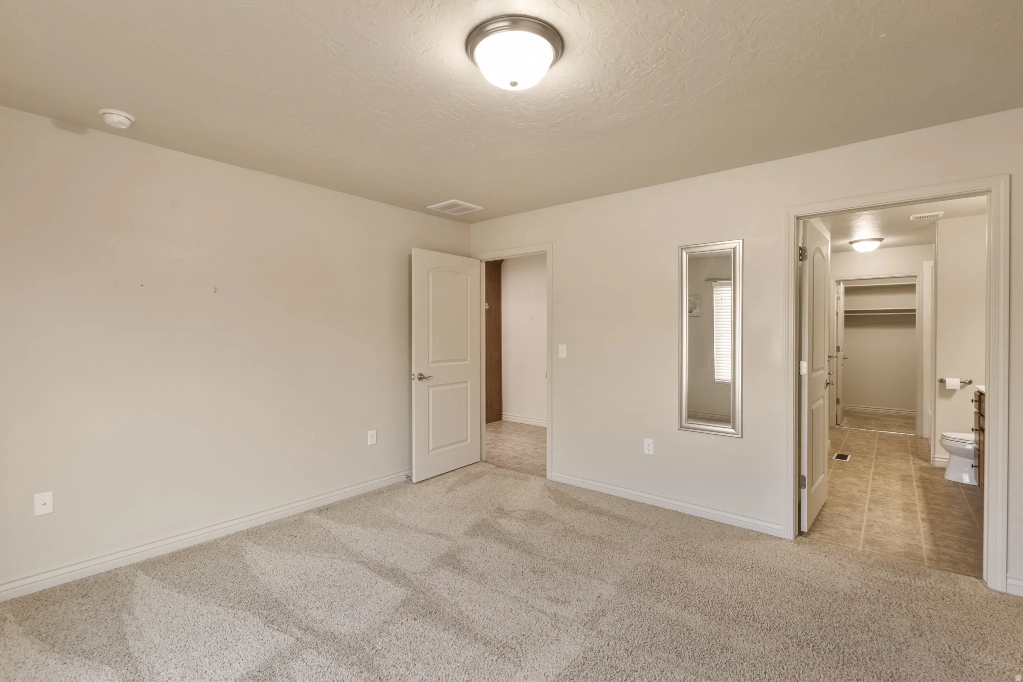 Plush carpeting, neutral wall finishes, recessed lighting, and white paneled doors