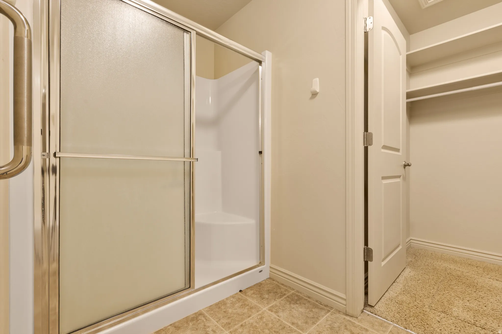 Shower enclosure with frosted glass panels and polished chrome hardware