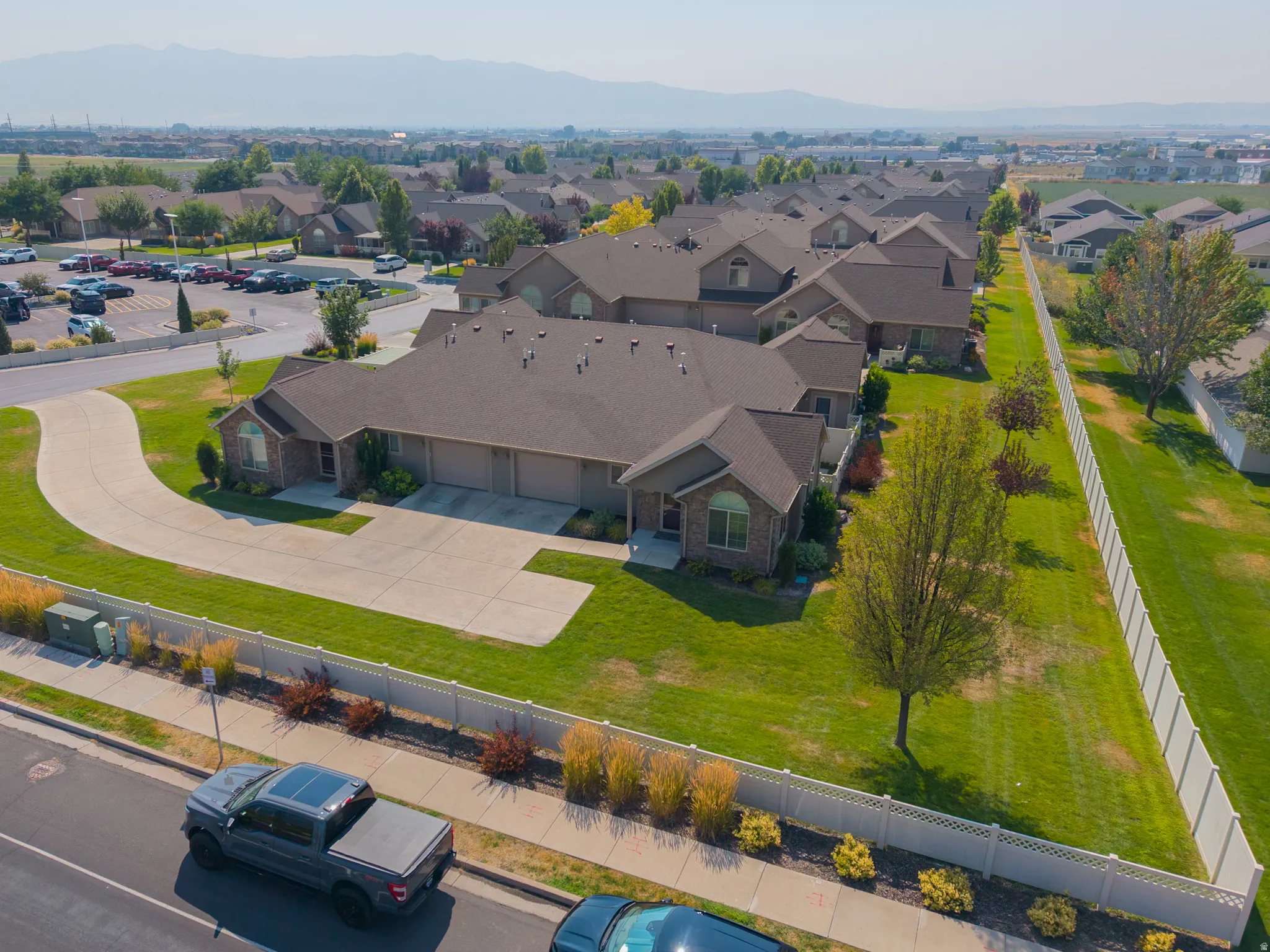 Multiple attached residential structures with brick exteriors, asphalt shingle roofs, and attached garages