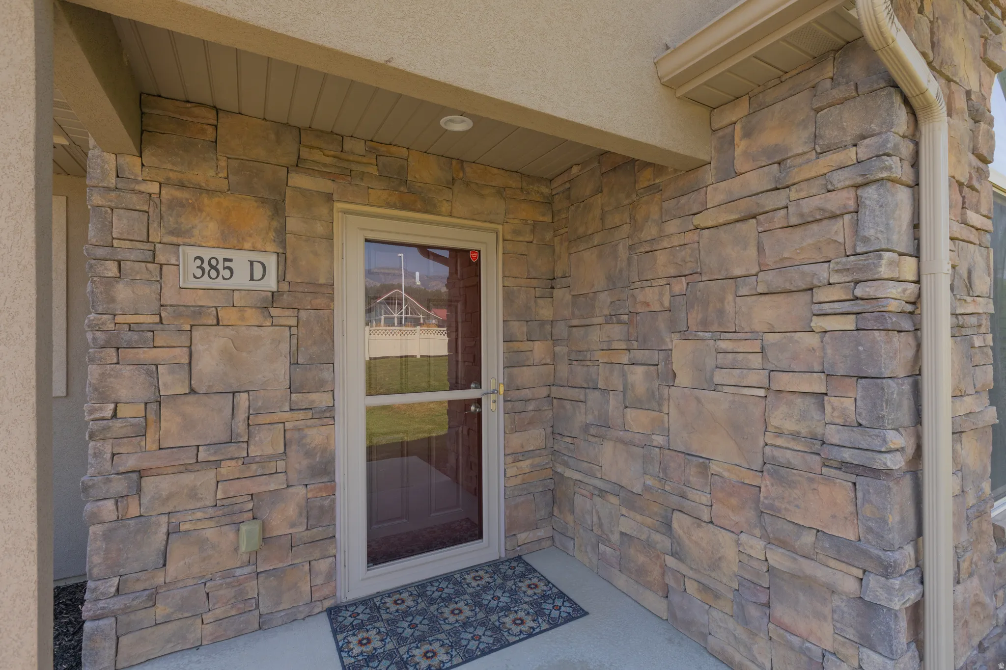 Stone veneer exterior with a covered entry