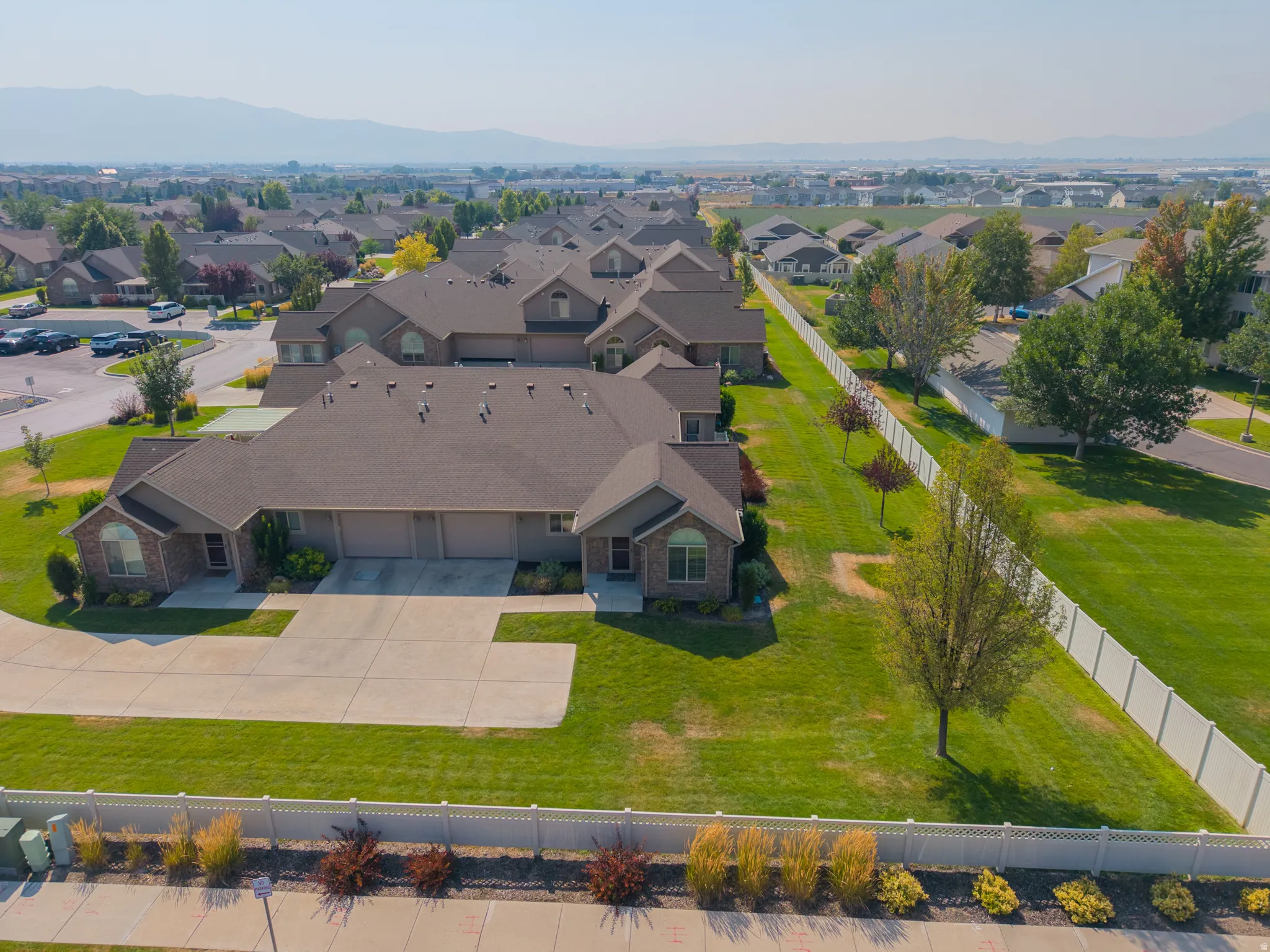 Brick-clad exteriors with attached garages, mature landscaping, and a fenced perimeter