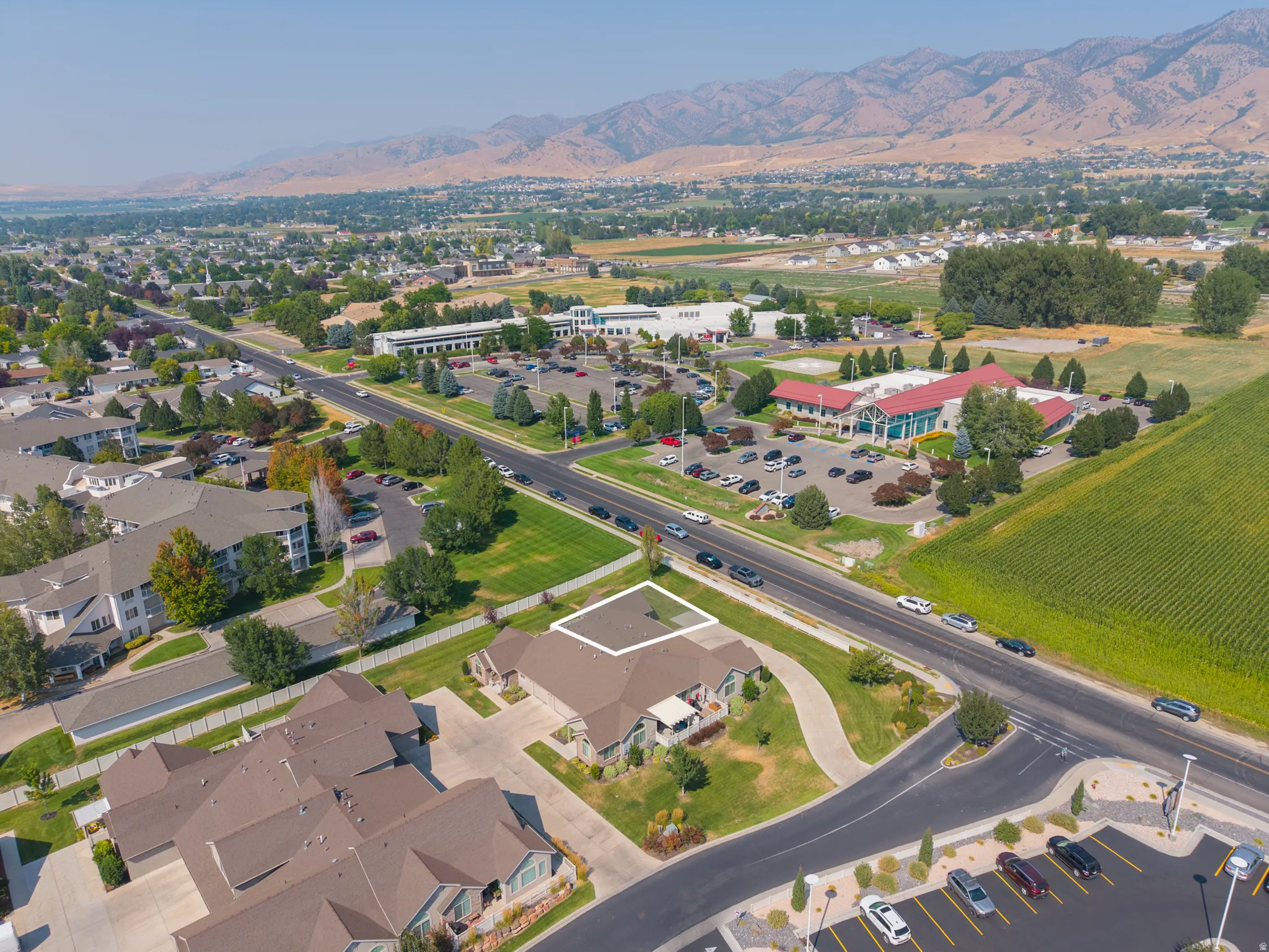 Expansive residential area with mountain backdrop, surrounded by established landscaping, and adjacent to commercial properties