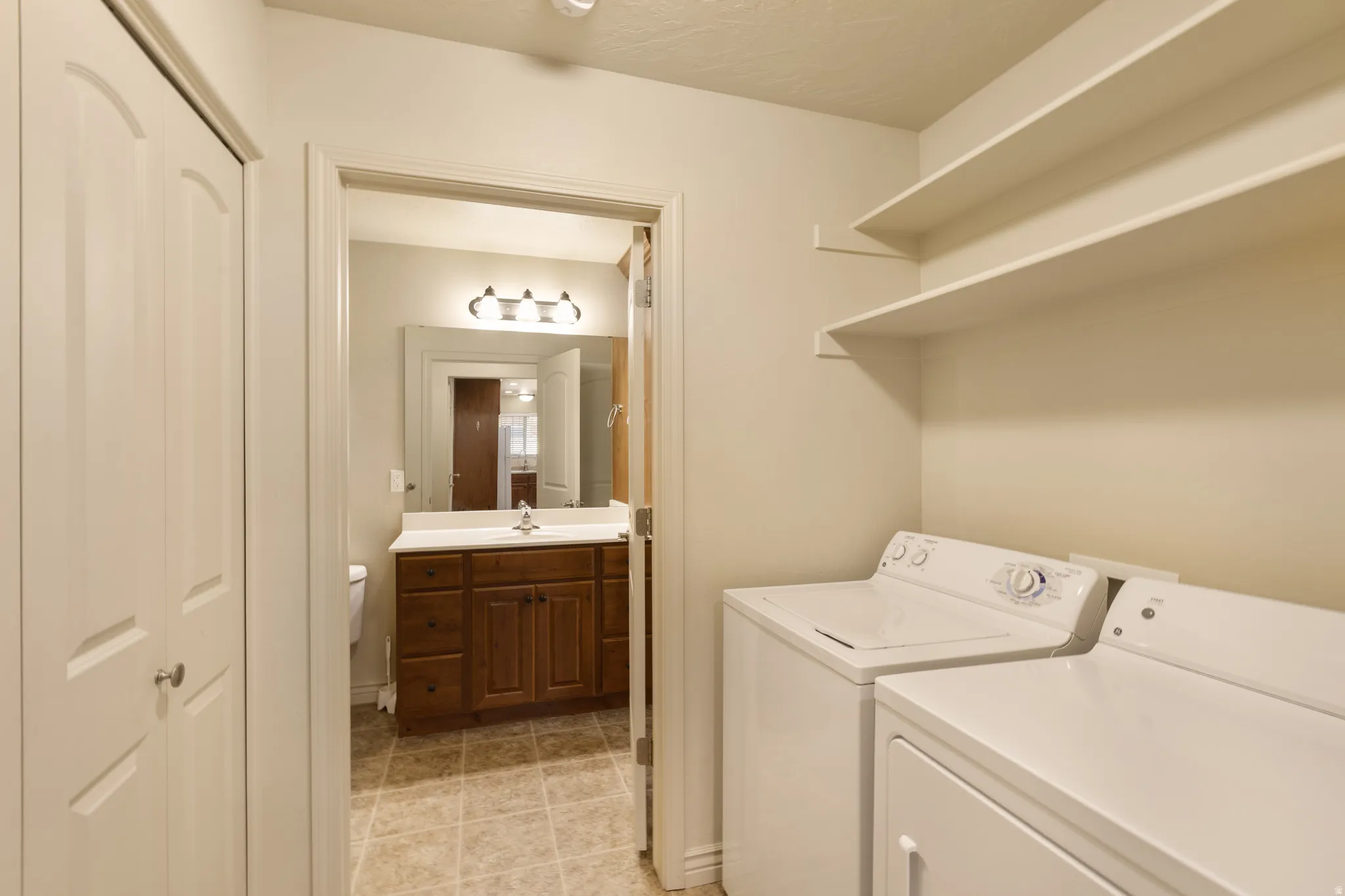 Built-in shelving, bifold closet doors, and tiled flooring