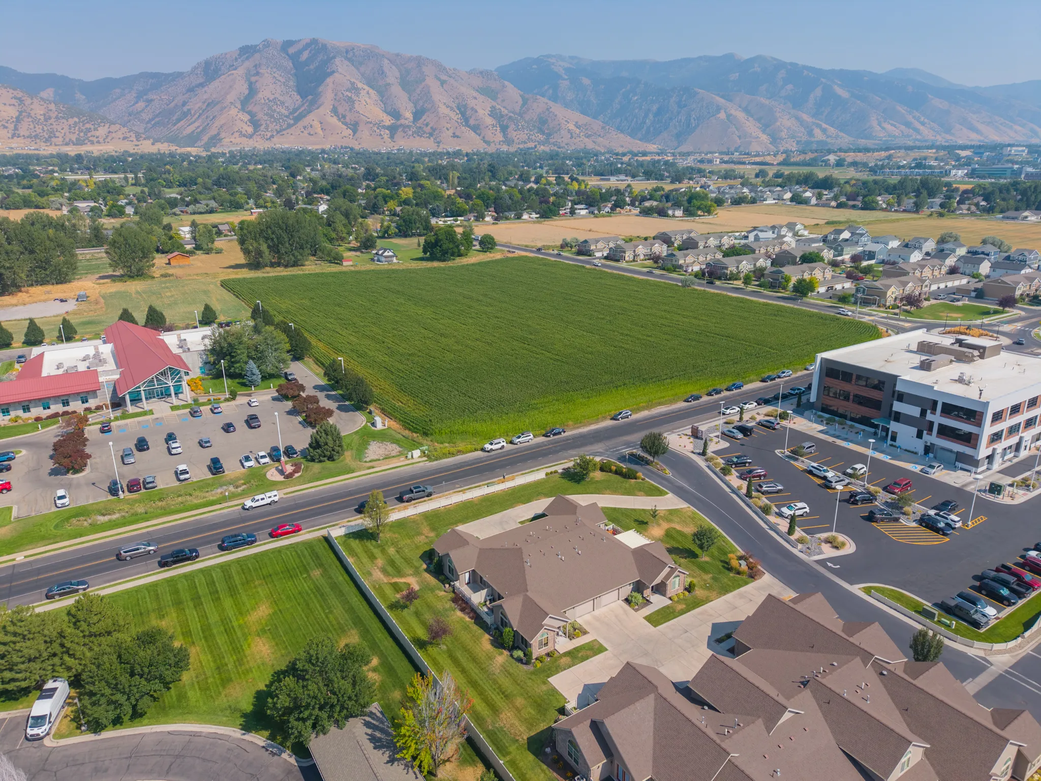 Aerial perspective showcasing expansive manicured grounds with mature landscaping, professional hardscaping, and established residential development