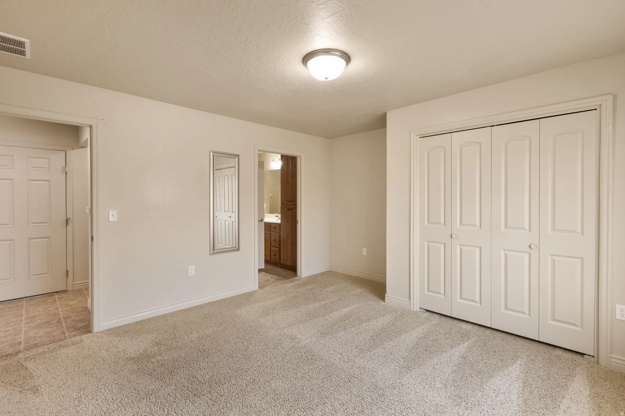 Neutral-toned carpeting throughout, bi-fold closet doors, and recessed ceiling lighting