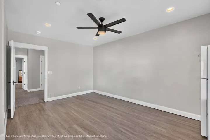 Wood-finish flooring, recessed lighting, and a black ceiling fan with integrated lighting