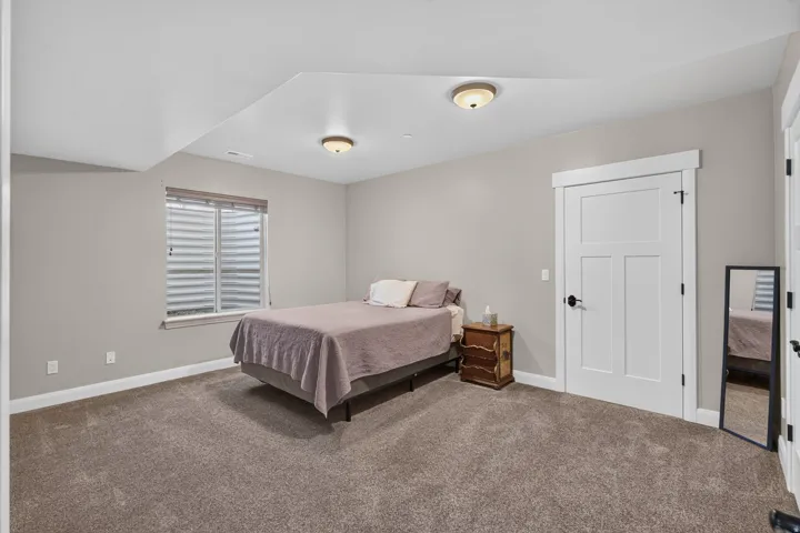 Neutral tone walls with white trim, recessed window, flush mount lighting, and a paneled door with black hardware