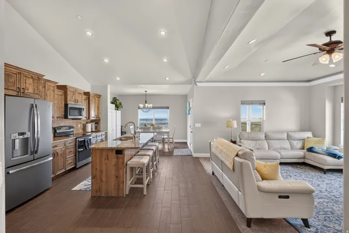 Open-concept design featuring wood-finish flooring, recessed lighting, and a vaulted ceiling
