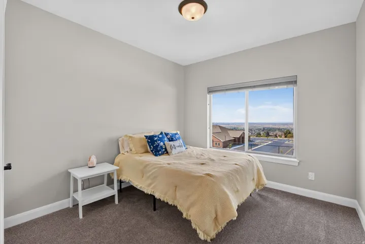 Neutral wall color, carpeted flooring, large window with blinds, ceiling-mounted light fixture
