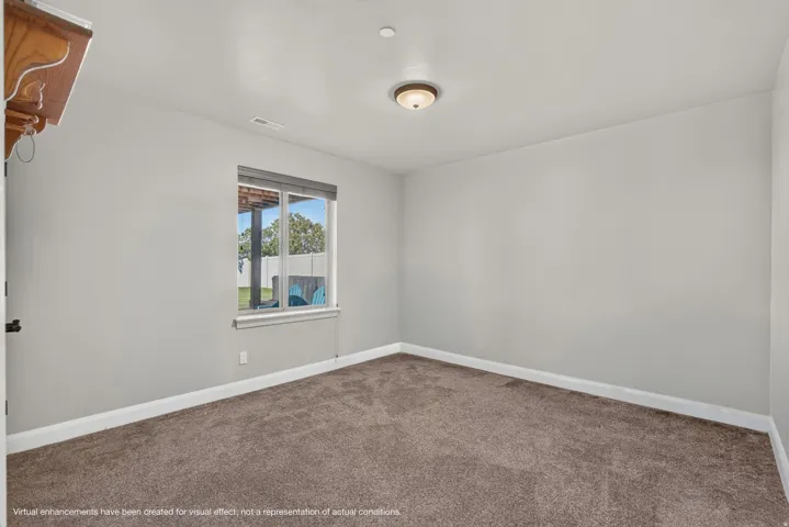 Recessed lighting, neutral wall tones, carpeted flooring, and a single window with blinds