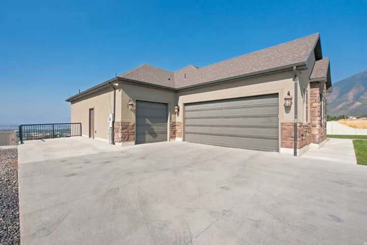 Stucco and stone exterior with a multi-car garage