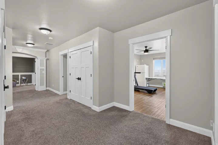 Gray wall paint with white trim, recessed lighting, and a window in the adjacent room