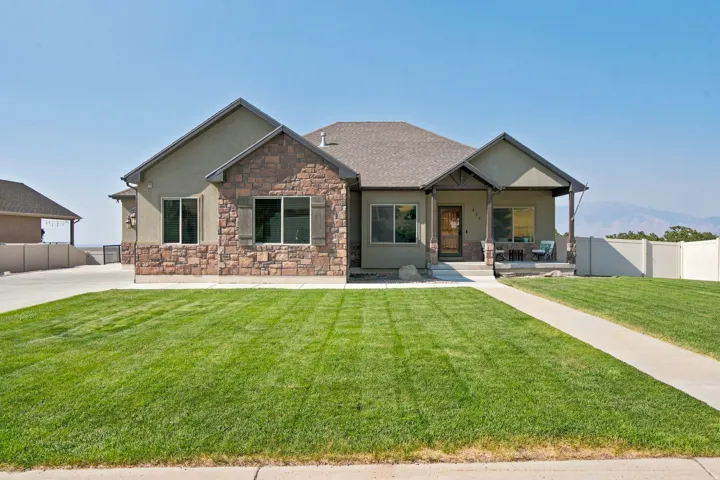 Ranch-style residence featuring a prominent stone facade and stucco exterior