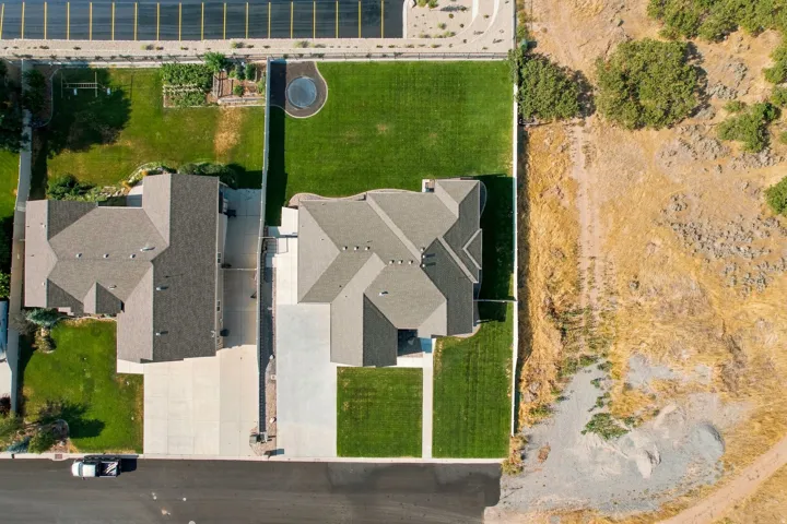 Extensive property featuring a large structure, concrete driveways, and manicured lawns