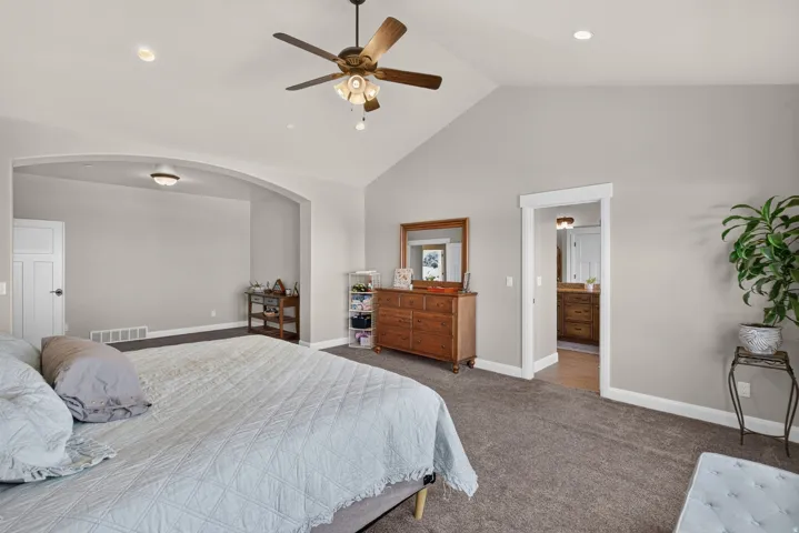 Vaulted ceilings with ceiling fan, recessed lighting, arched doorway, and carpet flooring