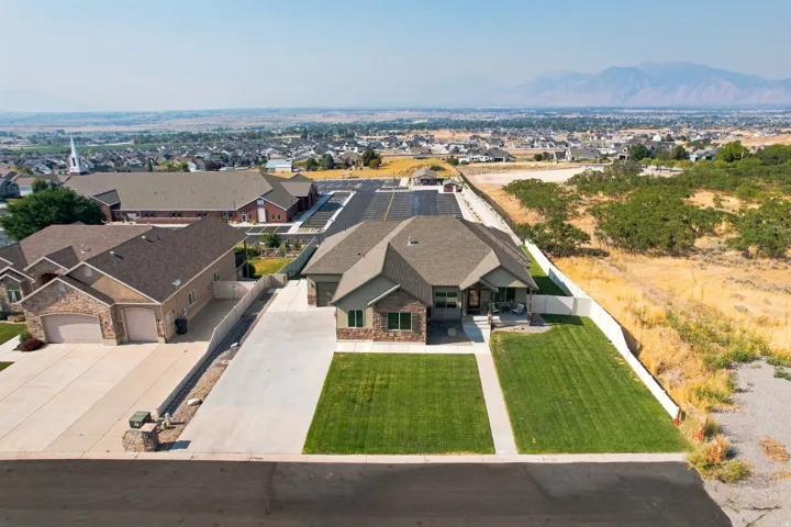 Single-story home featuring a covered entry, stone and siding exterior, two-car garage, and manicured front lawn