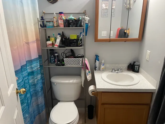 Recessed medicine cabinet, single vanity with laminate countertop, integrated sink, and wood-finish cabinetry