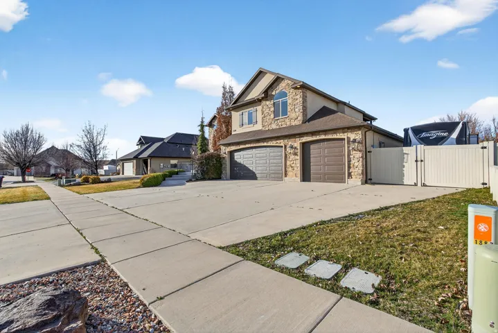 Stone veneer exterior with a two-car garage, an additional single-car garage, and a gated side yard