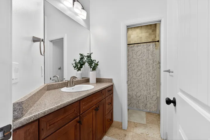 Vanity with a built-in sink, wood-finish cabinetry, and a countertop
