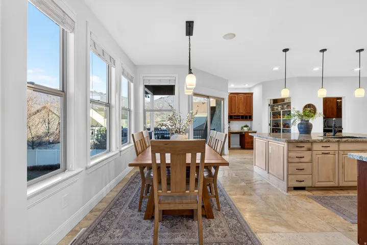 Dining area with multiple vertical windows, tile flooring, and a linear pendant light
