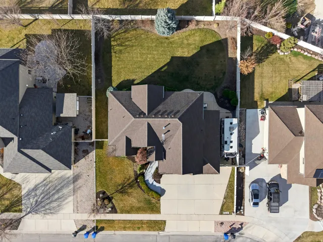 Expansive backyard with manicured lawn, established landscaping, and perimeter fencing