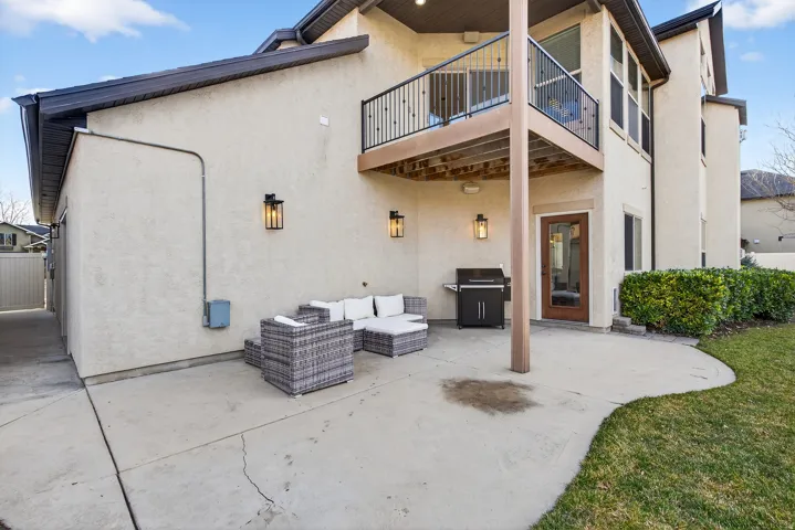 Expansive concrete patio with direct outdoor access and exterior wall sconces