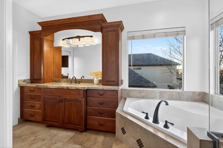 Built-in wood cabinetry with a light-colored countertop, undermount sink, and wall mirror