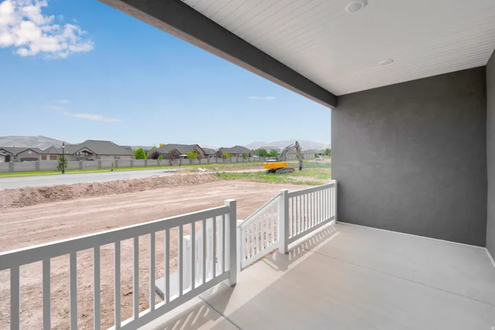 Covered concrete patio featuring white railing and recessed lighting