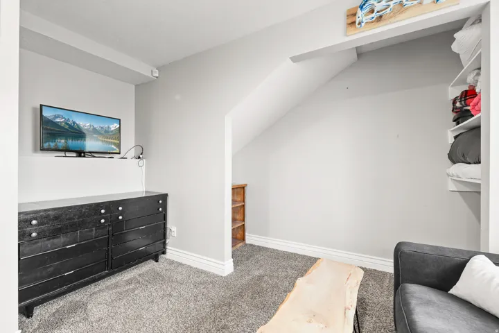 Sloped ceiling architectural detail, built-in shelving, and light gray wall paint