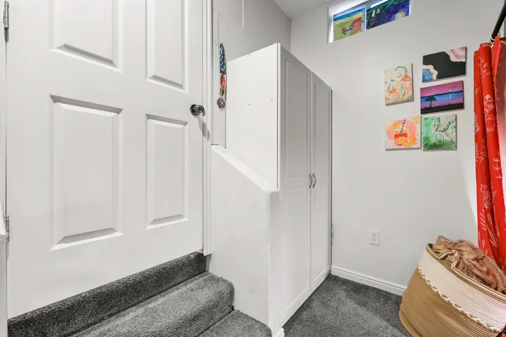 Bright entry foyer featuring neutral wall finishes, gray tile flooring, and a six-panel white entry door with sidelite window