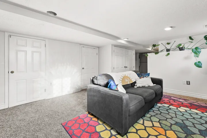 Recessed lighting illuminates the carpeted flooring and white walls